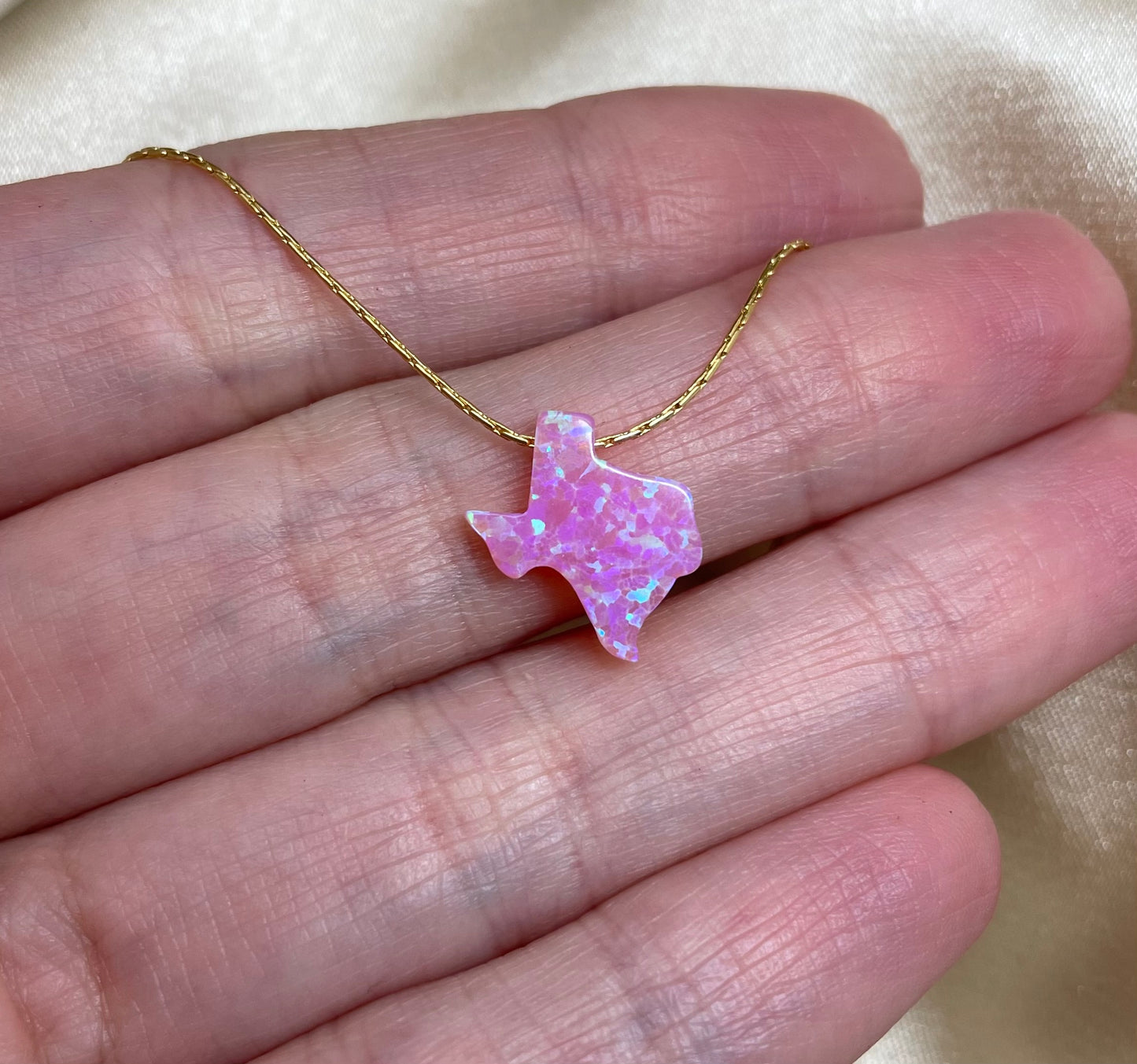 Pink Texas-shaped pendant on a gold chain