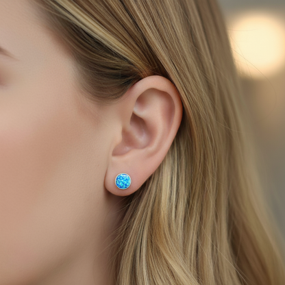 Close-up of a person wearing a blue opal earring with blurred background